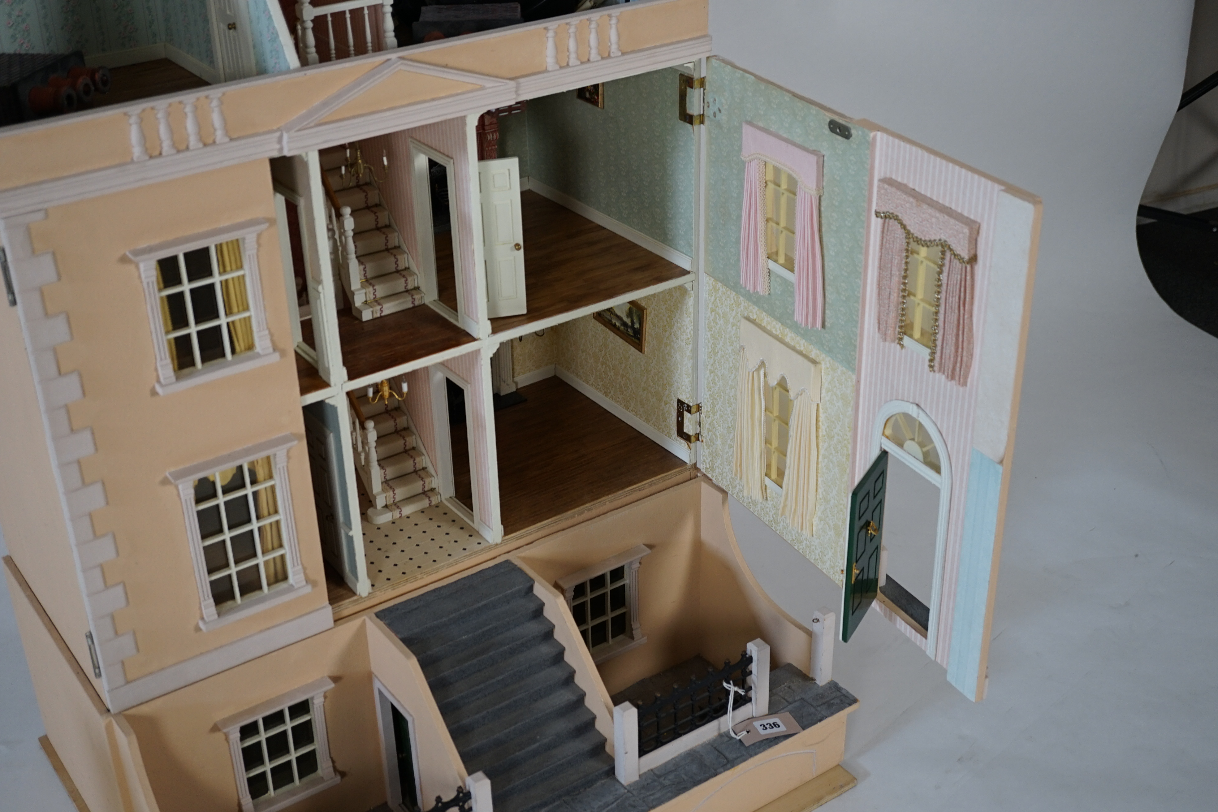 A large modern Georgian style dolls house and extensive contents, with eight fully decorated rooms on four floors, and fitted with electric lighting, removable front steps and pavement section to access basement rooms, 1